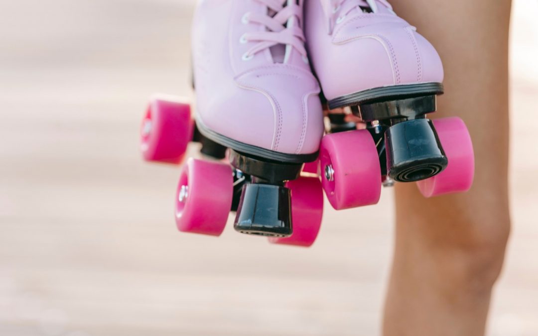 Female holding pink rollerskates.